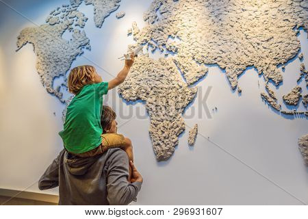 Dad And Son On The Background Of A World Map With An Airplane In His Hands. Travel Concept