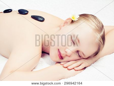 Spa Massage With Sones. Beautiful Young Woman Getting Spa Massage On Salon