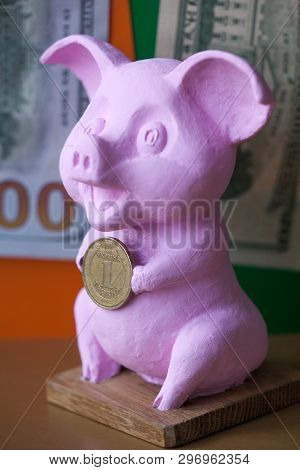 Pink Pig Holding Hryvna Coin. Pig With Hryvna Coin Against The Background Us Dollars Background. Uah