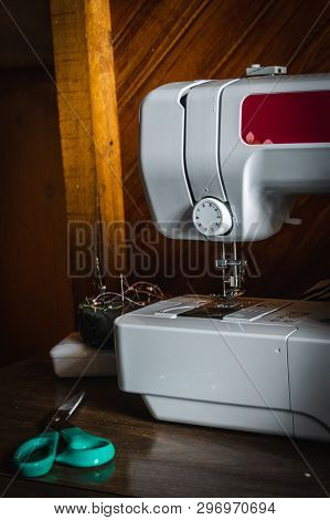 Front View Of A Modern Electric Sewing Machine Isolated On White With Scissors