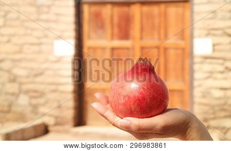 Closed Up A Fresh Ripe Chilean Pomegranate On Woman Hand
