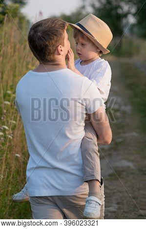 Portrait Of Fathe And Son At Meadow In Summer Day