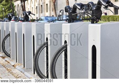 Urban Electric Bikes Charging Batteries In The City. For Rent