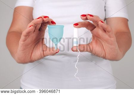 Womans Hand With Perfect Manicure, Holding Different Types Of Feminine Hygiene Products - Blue Menst