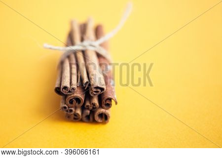Cinnamon Sticks Held Together With Jute Rope On The Yellow Background