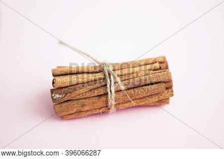 Cinnamon Sticks Held Together With Jute Rope On Pink Background