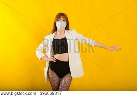 Female Strip Dancer In Yellow Studio In Protective Mask From Covid