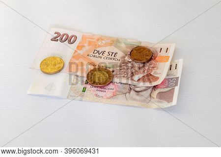 Czech Koruna Banknotes And Coins On White Table.