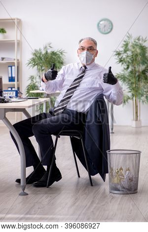 Old male boss employee working during pandemic