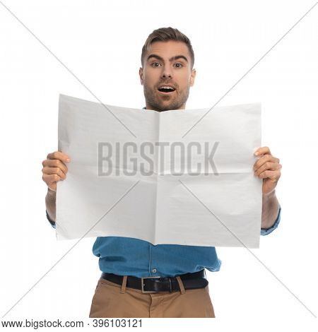 sexy casual man is feeling happily surprised because of the news he just read against white background