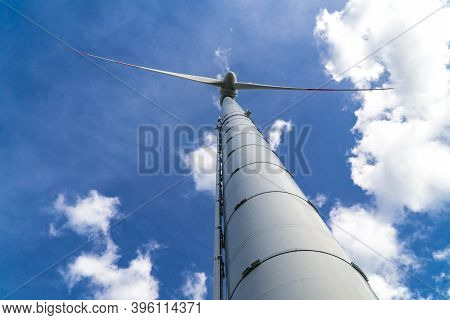Windmill For Electric Power Production Sourround Blue Clouds In Summertime In Germany