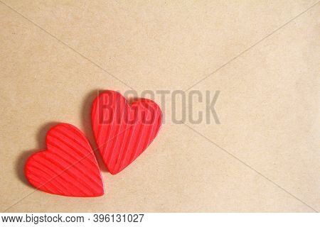 Two Red Wooden Hearts On An Old Paper Background. Creative Greeting Card For Valentine's Day. The Vi