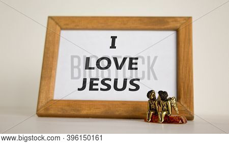 Wooden Picture Frame With Inscription 'i Love Jesus' On Beautiful White Background. Two Bronze Angel