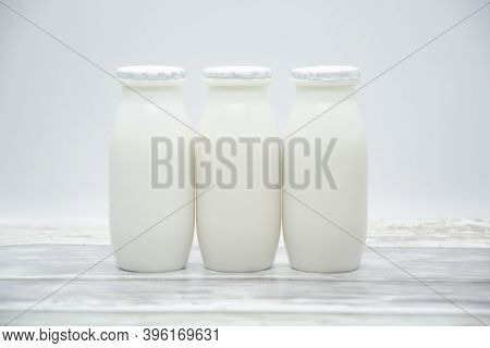 Natural Liquid Yogurt With Probiotics In Small Plastic Bottles On Wooden Table. Healthy, Balanced Di