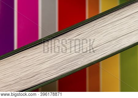 Closed Book On Background With Stripes Of Different Colors, Top View From The Butt. Education, Schoo