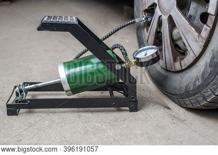 Foot Pump Near The Car With Flat Tire On The Road. Foot Pump For Pumping A Car Tire. Car Repairs. Ma