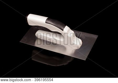 Plastering Trowel Tool For Smoothing In Constructions Isolated On The Black Reflective Background