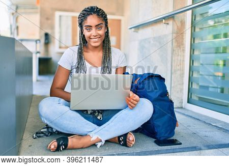 Young african american student woman smiling happy using computer laptop at the university campus