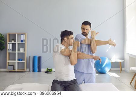 Physiotherapist Teaching Patient To Do Cross-body Stretch To Ease Pain And Cure Shoulder Stiffness