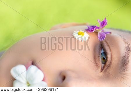 Macro Shot Half Of Womans Beautiful Face With Wild Flowers And Daisy On Skin. Search For Harmony, Na