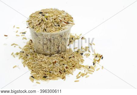 Isolated Raw Mix Brown Rice In Plastic Measuring Rice Cup On White Background. Close Up Organic Raw 