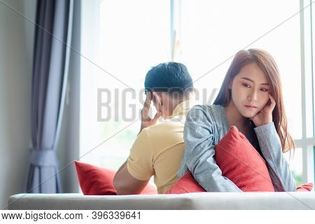 Unhappy Couple Sitting Behind Each Other On The Couch And Avoid Talking Or Looking At Each Other, Ca