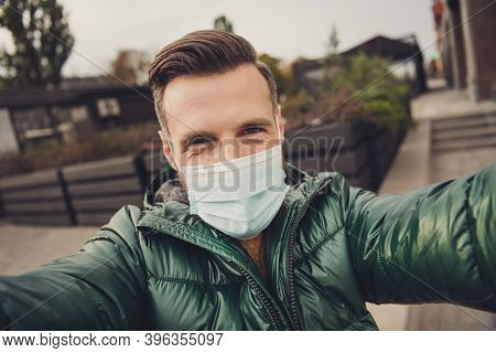 Photo Of Cute Good Mood Young Guy Dressed Green Coat Protection Mask Making Selfie Outdoors City Str