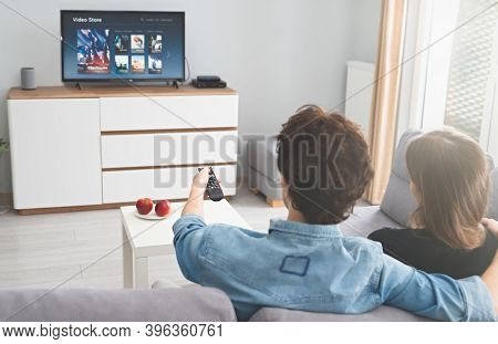 Couple Watching Tv On Sofa. Television, Multimedia, Video On Demand Service