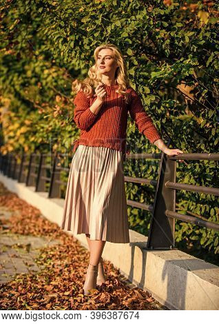 Autumn Woman. Girl Walk In Park. Girl In Corrugated Skirt And Sweater. Pleated Trend. Sunny Day With