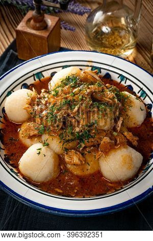 Dumplings With Turkey And Chorizo Sauce In A Painted Bowl.