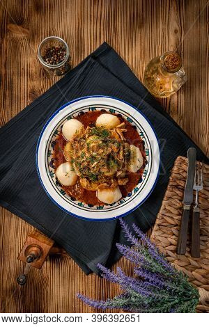 Dumplings With Turkey And Chorizo Sauce In A Painted Bowl.