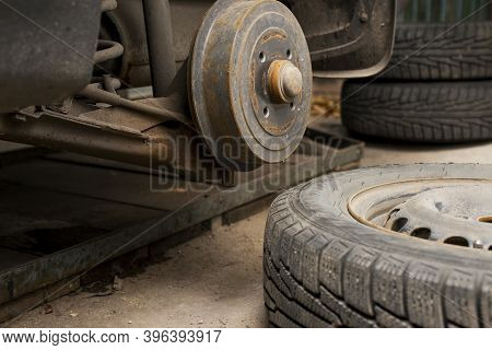 Car On Tire Mounting With Removed Wheel. Wheel Hub Closeup. Seasonal Tire Change. Empty Rusty Hub Wi