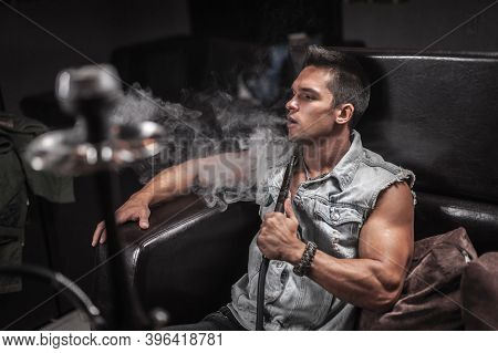 Man Smoking Hookah In The Shisha Bar.