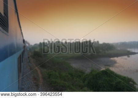 Blurred Image Of A Trian Running Towards Horizon Where Sun Is Rising, Indian Railway Stock Image,