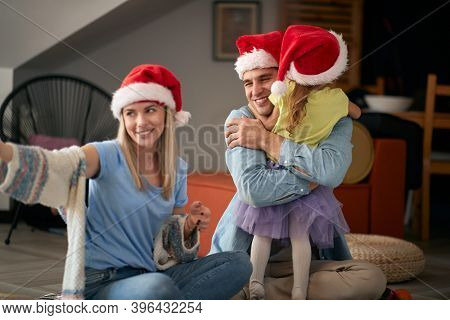 Happy parents spening Christmas time together with their kid; Family holiday concept