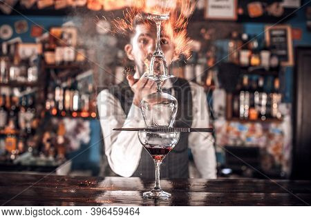 Focused Bartender Intensely Finishes His Creation At Bar
