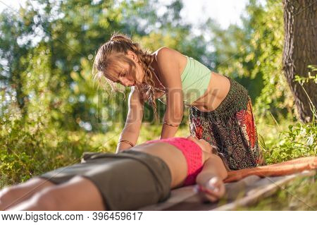 Experienced Masseuse Impliments Her Massage Abilities On The Forest Ground.