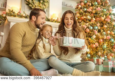 Young Family Feeeling Happy Opening Christmas Gifts