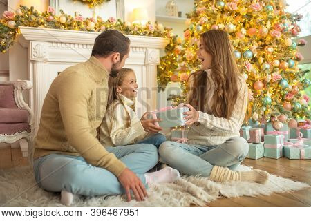 Young Family Feeeling Happy Opening Christmas Gifts