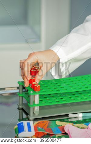 The Technicians Hand Puts Tests Of Empty Blood Tube To A Rack In The Lab