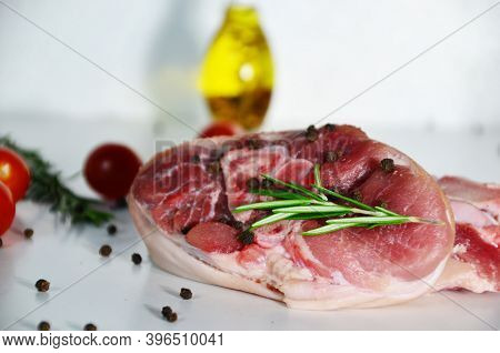 Pieces Of Raw Pork Steaks, With Ingredients For Cooking, Served On Woodenboard. With Rosemary, Cherr