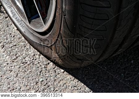 Close Up Of A Punctured Flat Tire On The Asphalt.