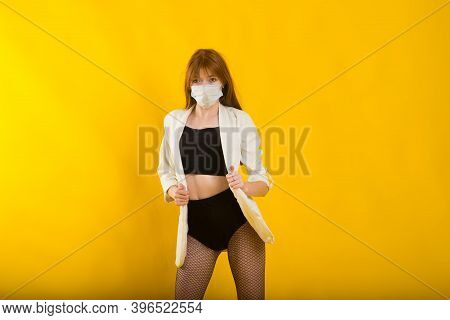 Female Strip Dancer In Yellow Studio In Protective Mask From Covid
