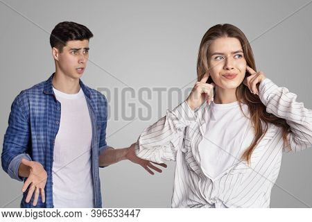 Quarrel And Showdown. Sad Woman Covers Her Ears With Fingers, Upset Man Expresses Negative Emotions,