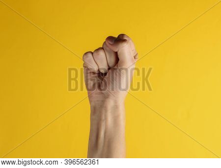 Femen Symbol. Fist Gesture Of A Female Hand On Yellow Background