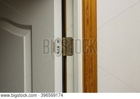Close Up View Of Open White Door  With Retro Gold Door Hinge.