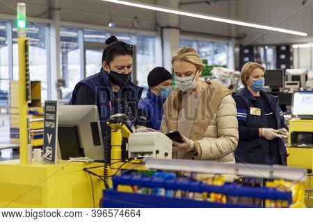 Shoppers Wearing Medical Masks At A Self-checkout Counter In A Supermarket. Coronavirus Pandemic. Mo