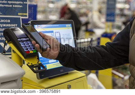 A Customer At A Self-service Checkout In A Supermarket Pays For Purchases With A Credit Card At The 
