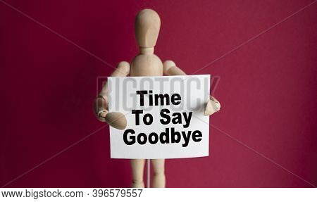 The Wooden Man Holds A White Sign With The Text Time To Say Goodbye In His Hands. The Content Of The