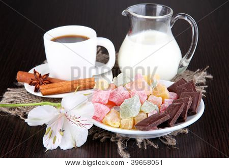 Tasse Kaffee mit Rahat Freude und Milch auf Holztisch